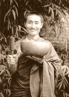 Lama Lobsang Molam playing a large Tibetan singing bowl with a padded mallet